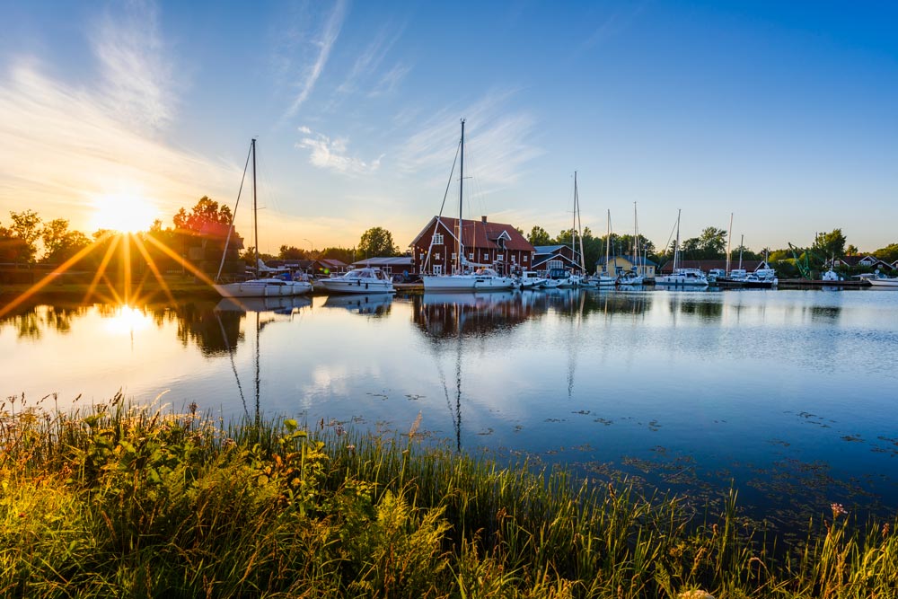 Göta canal with boats in wide sunset in summer